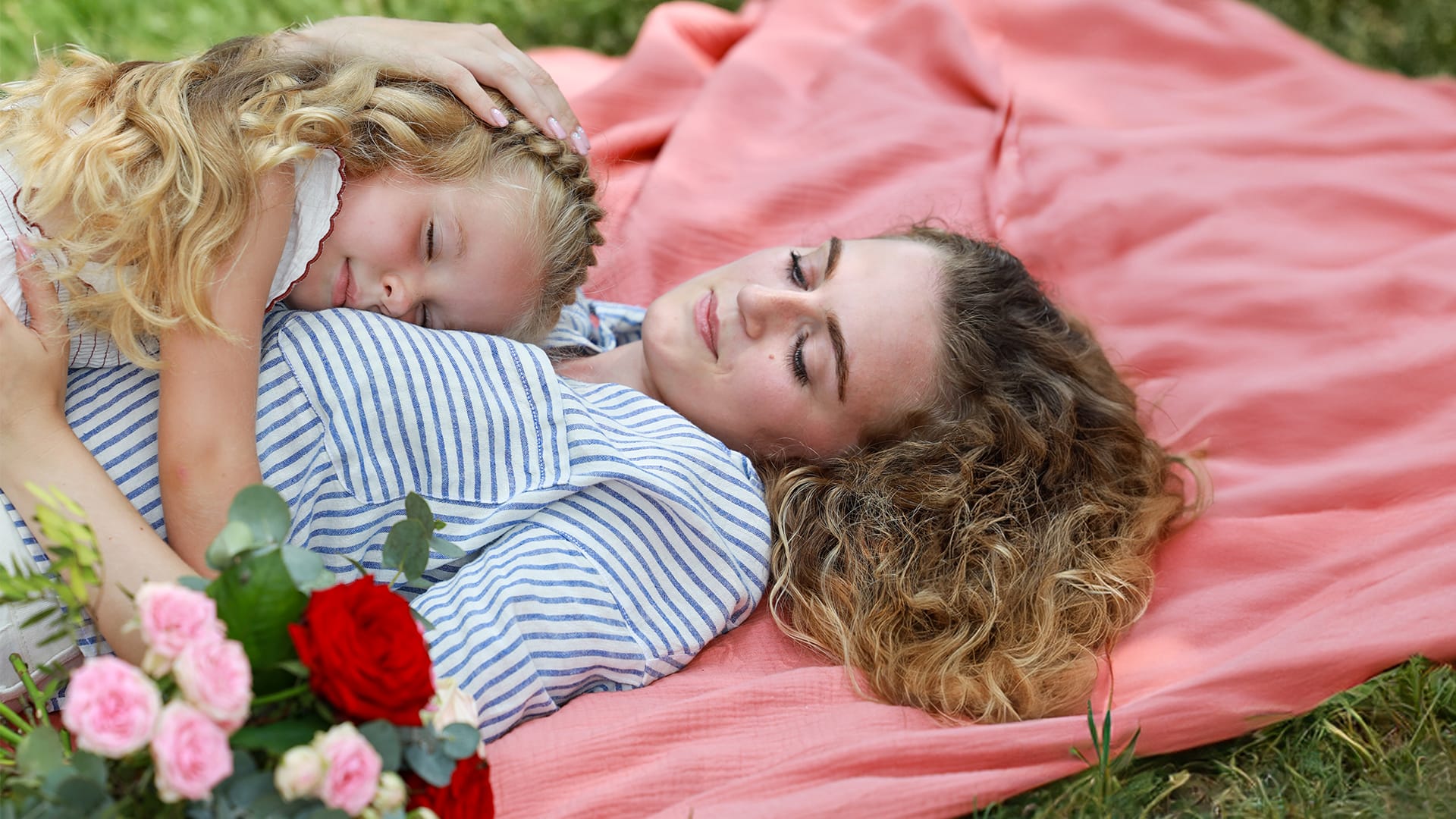 fille allongé sur sa mère avec bouquet de fleurs