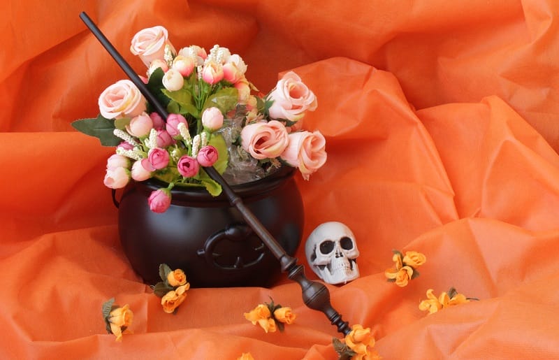 Chaudron noir servant de vase pour des fleurs avec un décor d'Halloween