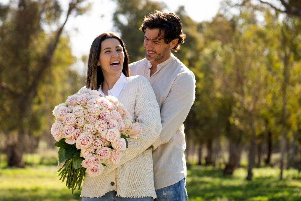 Couple calin dehors avec un bouquet de roses