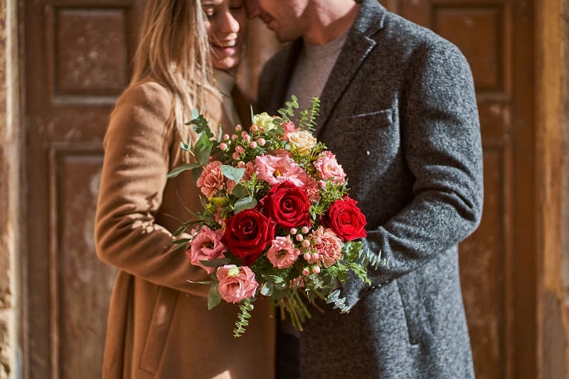 Couple d'amoureux tenant un bouquet de fleurs dans les mains