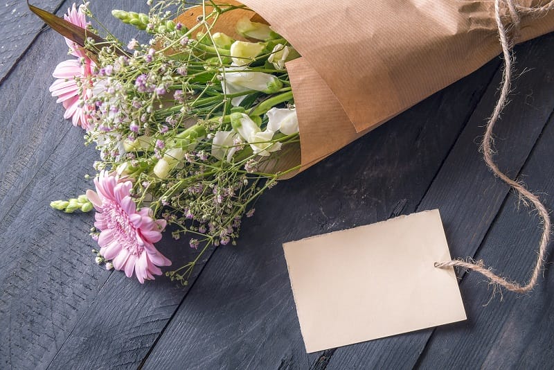 Carte de vœux attachée à un bouquet de fleurs