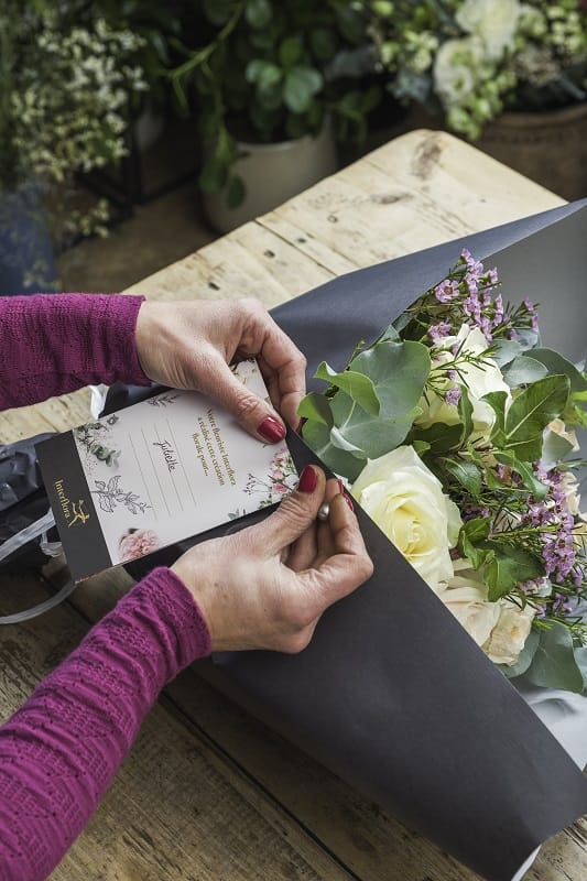 Carte accrochée à un bouquet de fleurs